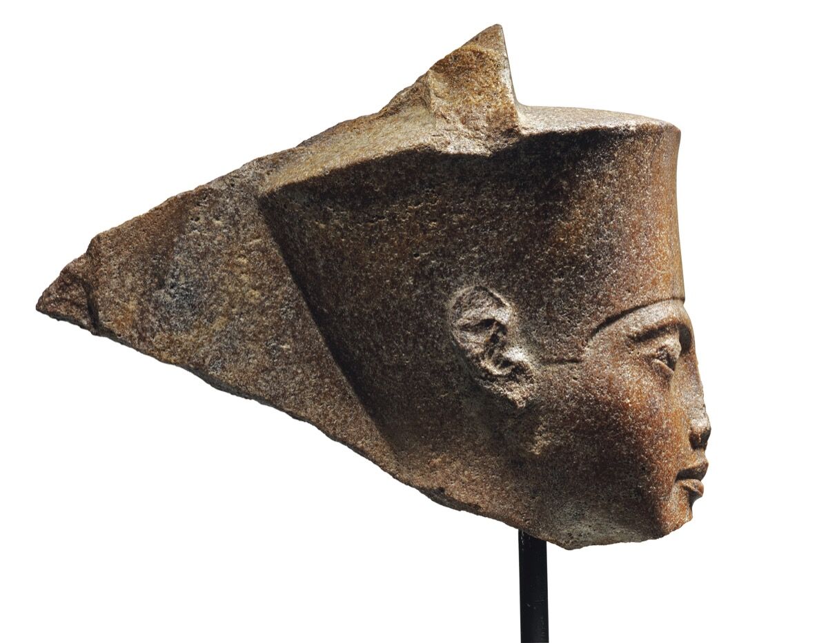 Una cabeza de cuarcita marrón egipcia del dios amén con las características del faraón Tutankamón, ca.  1333–23 AEC Cortesía de Christie & # x27; s.