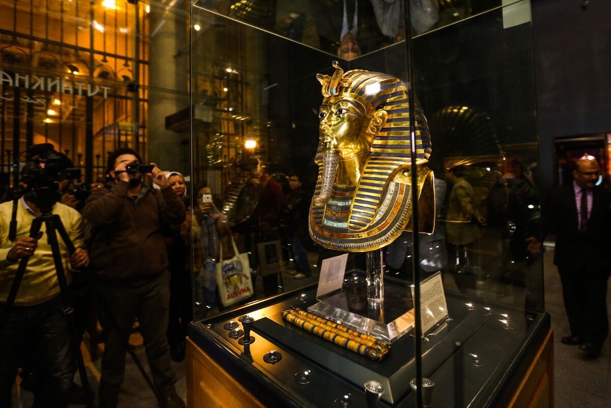 La máscara funeraria dorada del Rey Tutankamón en exhibición durante una ceremonia de inauguración en el Museo Egipcio, El Cairo, después de su proceso de restauración en 2015. Foto de Mostafa Elshemy / Agencia Anadolu / Getty Images.