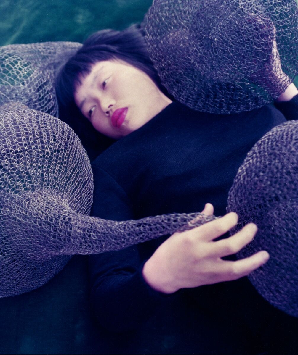 Portrait of Ruth Asawa reclining and encircled by a looped-wire sculpture, 1951. Photo by Imogen Cunningham. © 2019 Imogen Cunningham Trust. Courtesy of the Imogen Cunningham Trust.