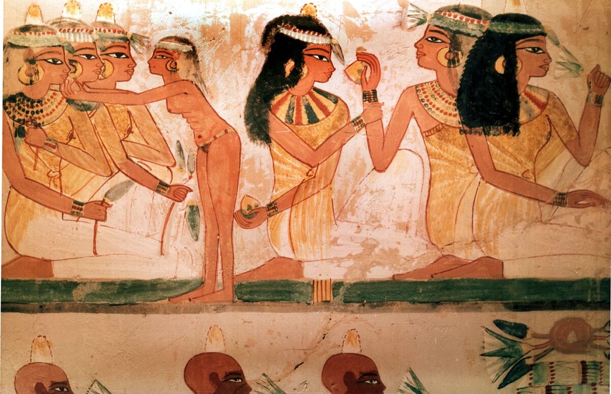A detail of a painting from the tomb of Nakht                    depicting three ladies at a feast. They wear perfumed                    cones in their hair and elaborate necklaces. Egypt,                    18th dynasty, ca. 1421–1413 B.C.E. Tomb no. 52, West                    Thebes. (Photo by Werner Forman/Universal Images                    Group/Getty Images).