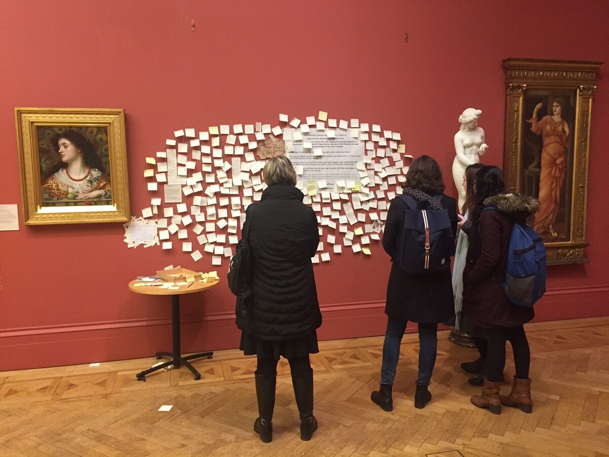 Los visitantes leen el comentario sobre notas, que se adjunta al lugar anteriormente reservado para la pintura Hylas and the Nymphs (1896) de John William Waterhouse. Foto de Britta Schultejans / Picture Alliance a través de Getty Images.
