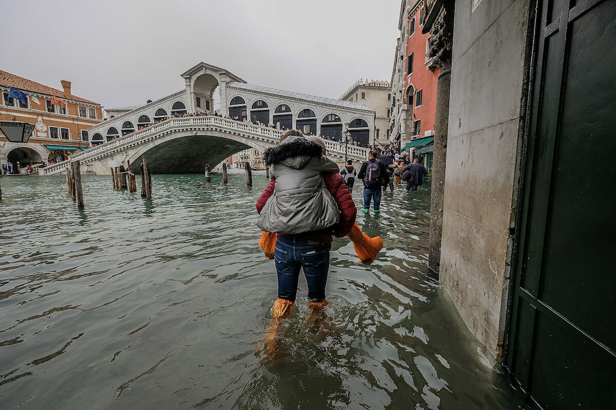 A tourist carries his partner on his shoulders in on October 29, 2018 in Venice, Italy. Photo by Stefano Mazzola/Awakening/Getty Images.