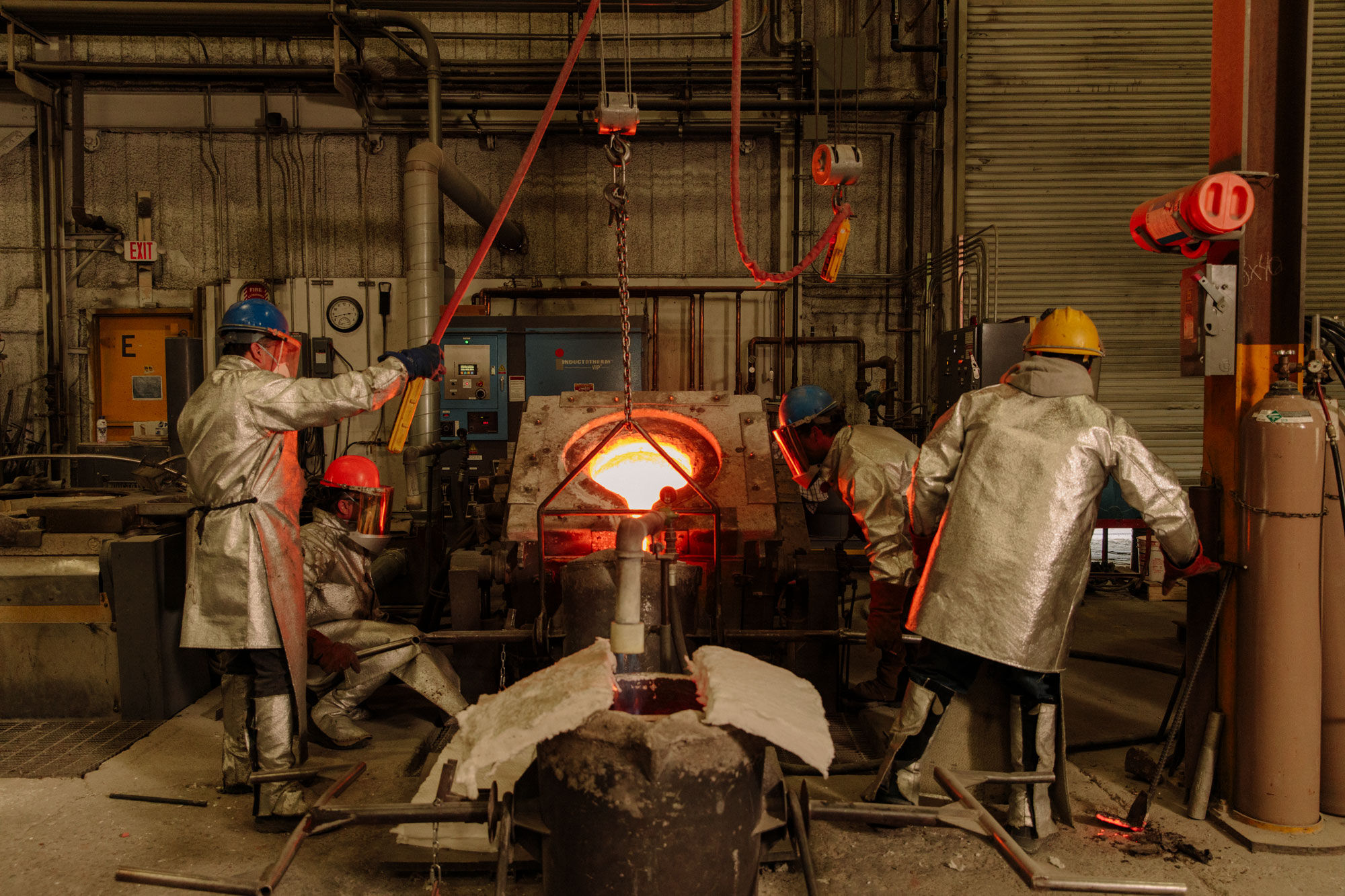 PTX foundrymen pouring molten metal into a crucible. Photo by Ricky Rhodes for Artsy.