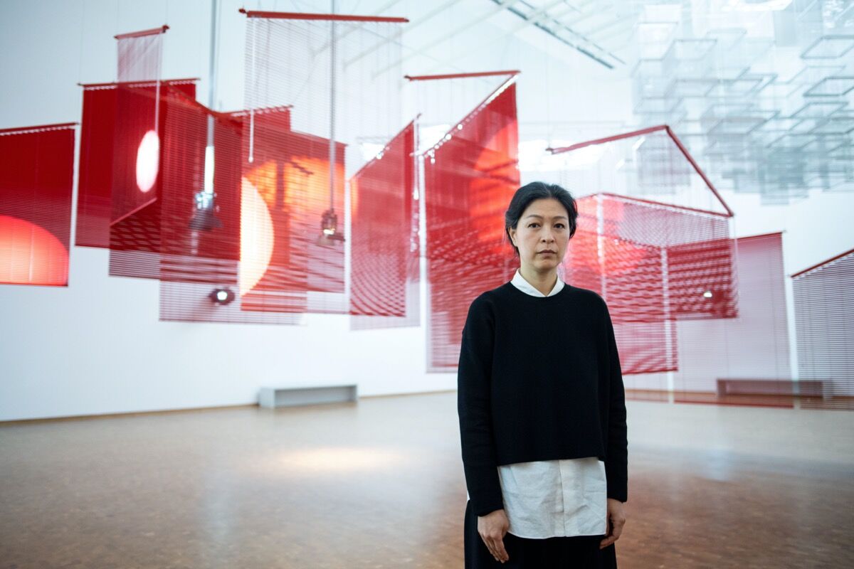 Portrait of Haegue Yang in front of her installation Mountains of Encounter, 2008, in “Haegue Yang: ETA 1994-2018” at Museum Ludwig, 2018. Photo by Marius Becker. Image via Getty Images.