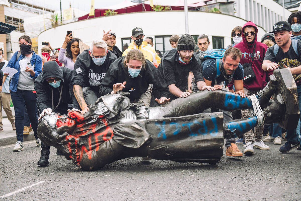 Black Lives Matter protesters rolling a statue of British slave trader Edward Colston. Photo by Giulia Spadafora/NurPhoto via Getty Images.