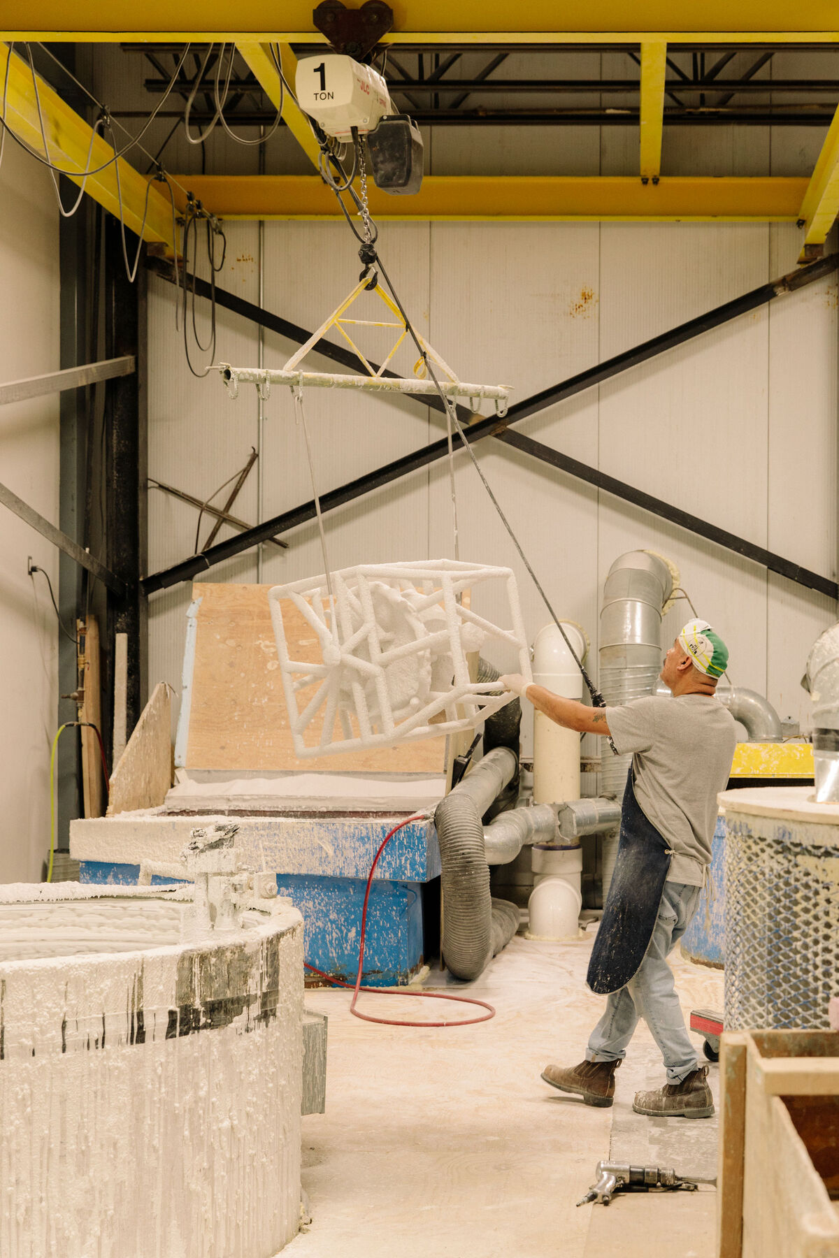 PTX Craftsman, Miguel Lucero, dipping wax to build ceramic shell for casting. Photo by Ricky Rhodes for Artsy.