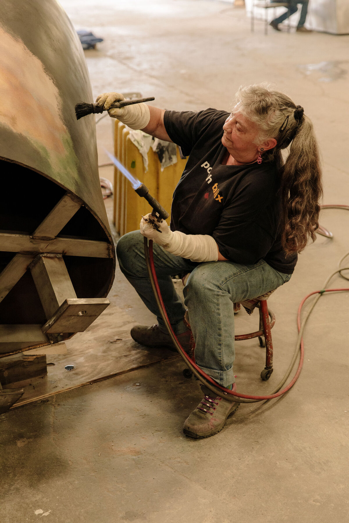 Rosemary Rednour is applying hot patina to a sculpture by Jim Sardonis. Photo by Ricky Rhodes for Artsy.