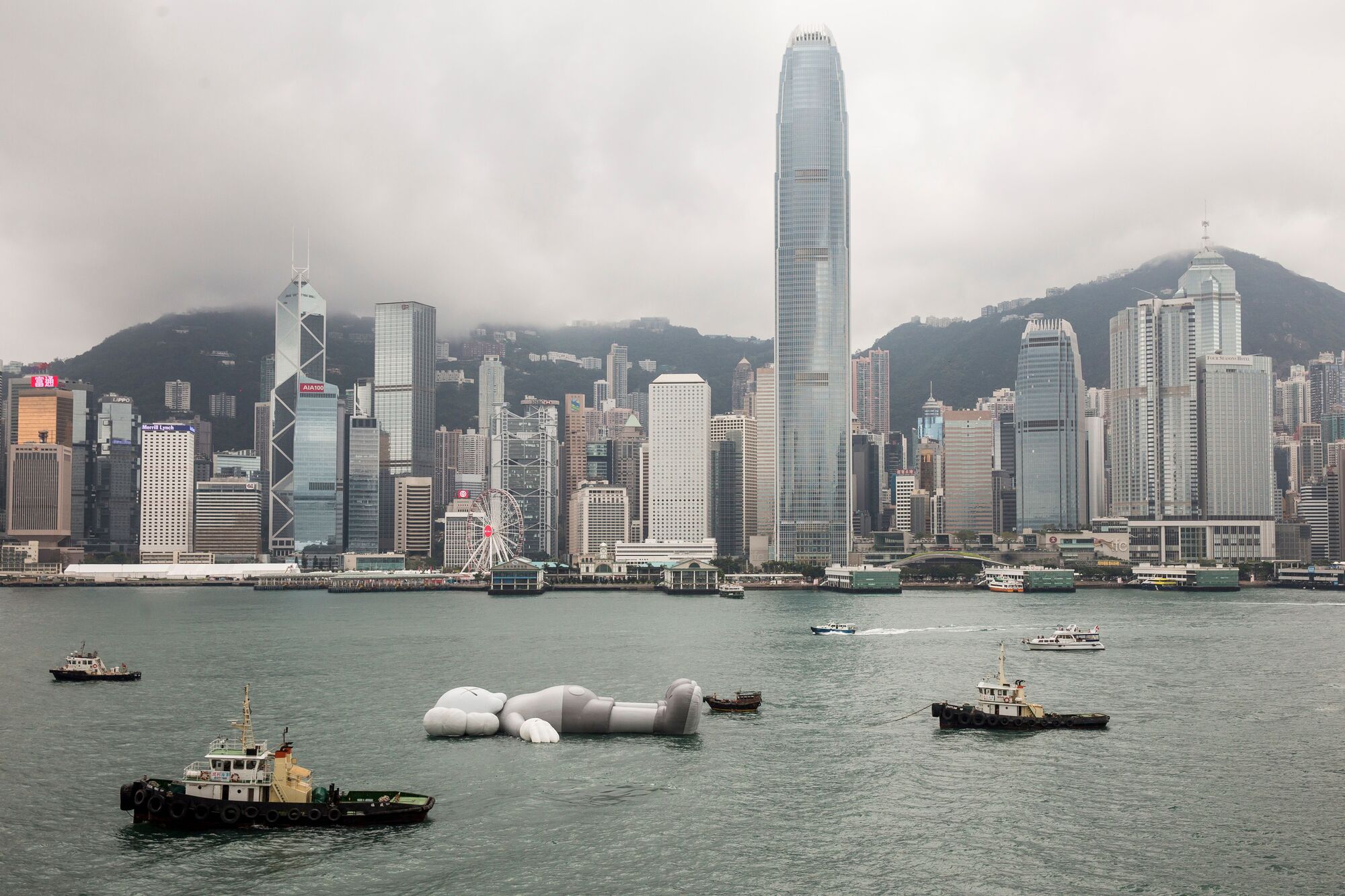 Companion, an inflatable sculpture by artist Brian Donnelly, known professionally as KAWS, is towed through Victoria Harbour before the opening ceremony for its exhibition in Hong Kong on March 22, 2019. Photo by Isaac Lawrence/AFP via Getty Images.