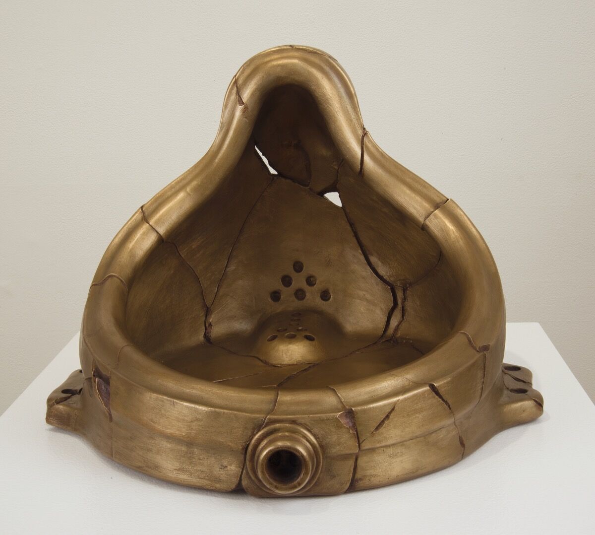 Black and white photograph of Marcel Duchamp’s Fountain, a porcelain urinal signed R. Mutt, displayed on a pedestal in an art gallery.