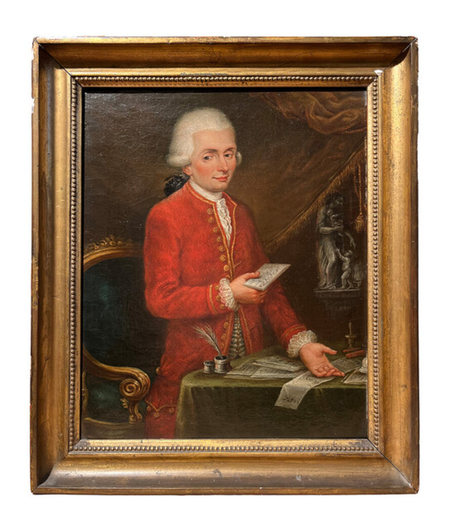 Portrait of a young musician in front of his desk with a score in his hand