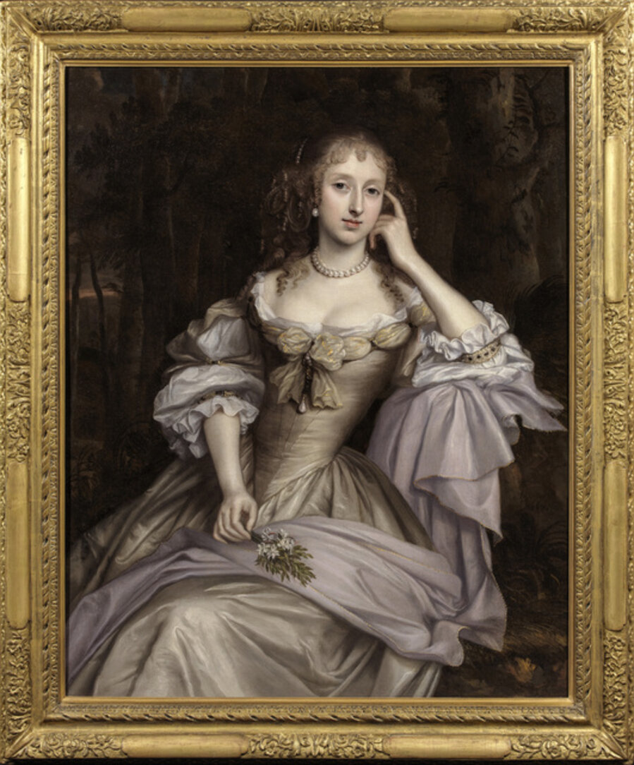 Portrait of Lady Hester Cotton, sitting on a ledge at the edge of a wood at evening, and holding a spring of orange blossom