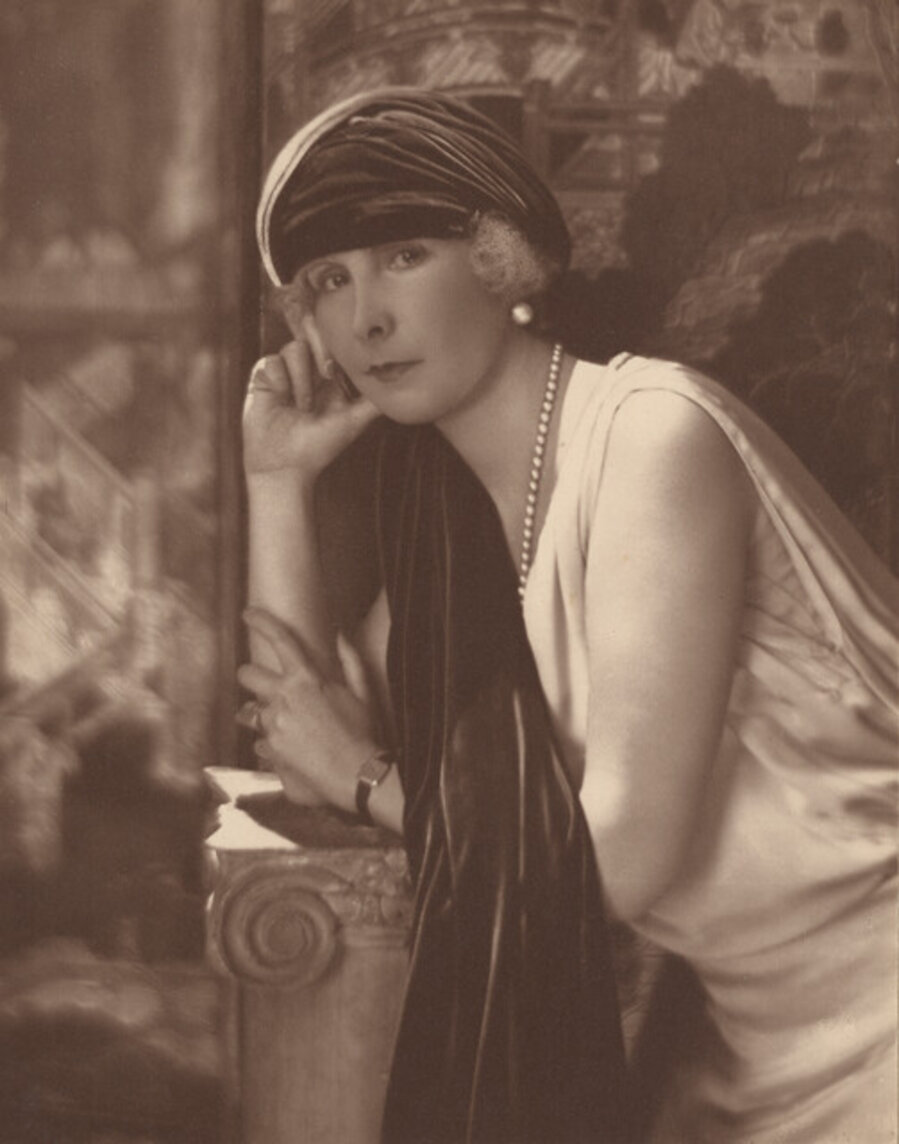 Posing woman in white dress and pearls