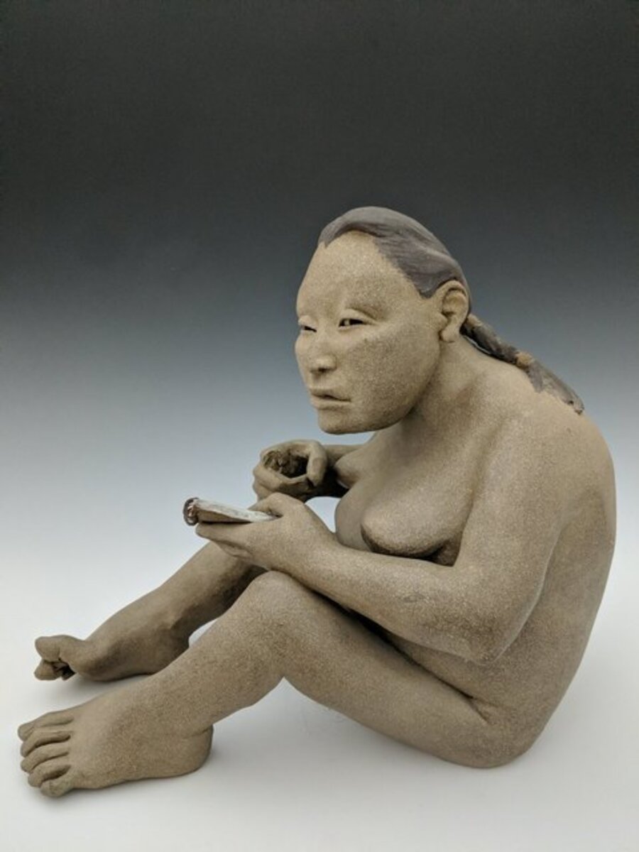 Seated woman with notepad (damaged)