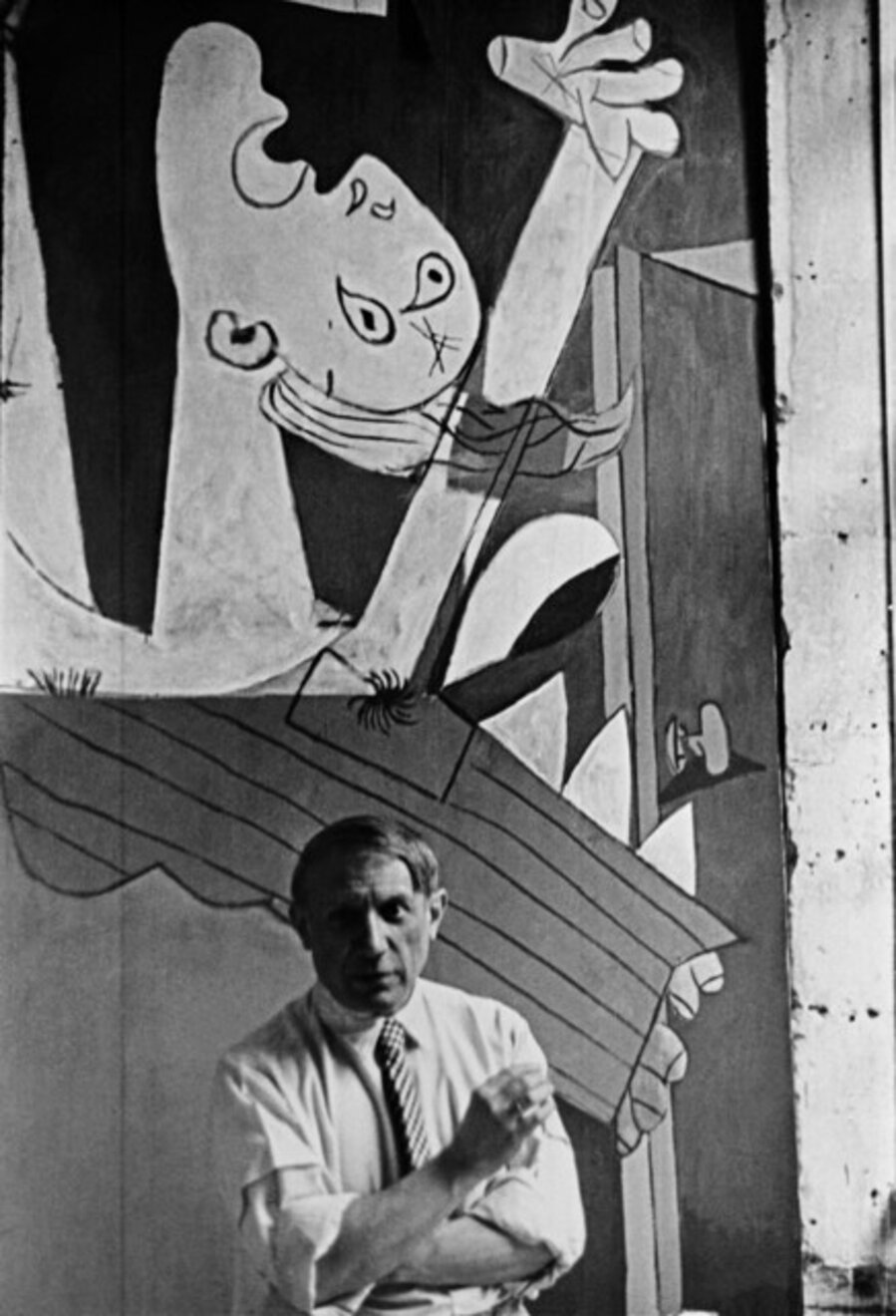 Pablo Picasso in front of his painting "Guernica", at its unveiling at the Spanish Pavilion of the International World Fair held six weeks after the aerial bombing of the Basque village of Guernica. Paris, France