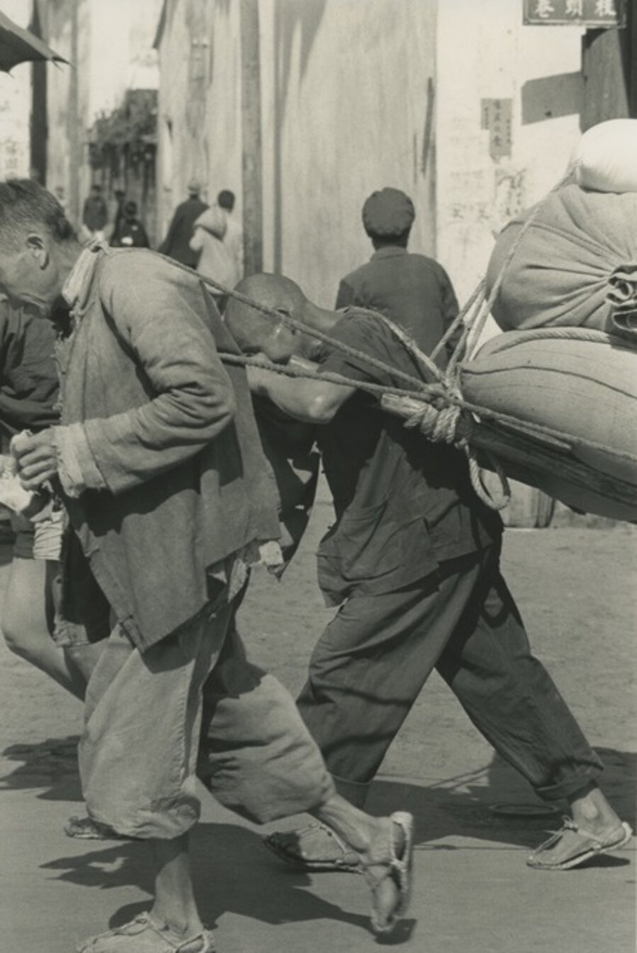 Men dragging sacks, China