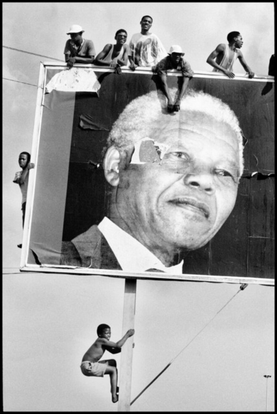 Supporters climb to every vantage point whilst awaiting the arrival of Nelson Mandela. Natal, Lamontville, South Africa
