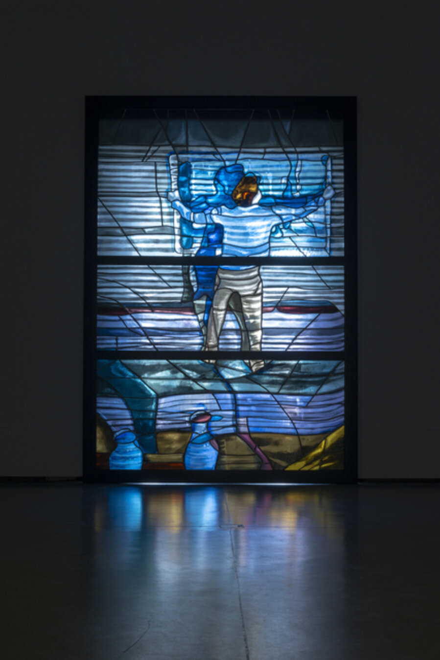 A man takes down a painting while standing on the sofa