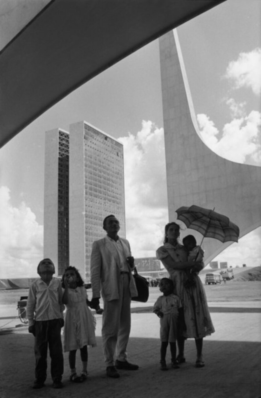 Worker shows his family Brasilia on the opening day, Brasilia, Brazil