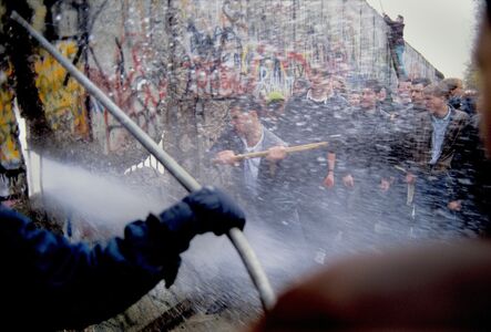 Alexandra Avakian, ‘Young West German Men Attack the Berlin Wall while East German Guards Shoot Water Cannon through the Cracks’, 1989
