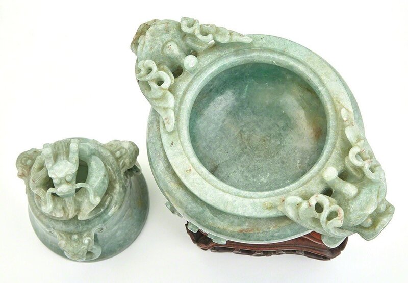 ‘Chinese Hardstone Covered Censer’, Design/Decorative Art, The compressed bombé body resting on three cabriole legs issuing from lion masks, the body flanked by a pair of dragon head handles suspending loose rings, the domed lid with three animal mask handles suspending loose rings and surmounted by a coiled dragon finial, the stone of a pale variegated celadon and apple green color., Doyle