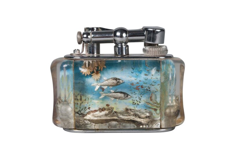 Dunhill, ‘an Aquarium table lighter’, 2nd Quarter 20th Century, Design/Decorative Art, The Perspex/Lucite panels decorated with fish amongst seaweed and rocky outcrops, the end panels with shells upon rocks, with plated mounts, Roseberys