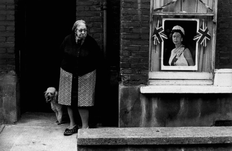 Old lady with her dog outside her front door during the Queen's Jubilee year. London, Great Britain