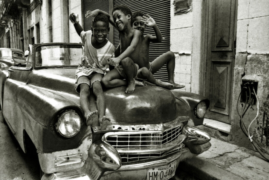 Ninos jugando sobre carro americano