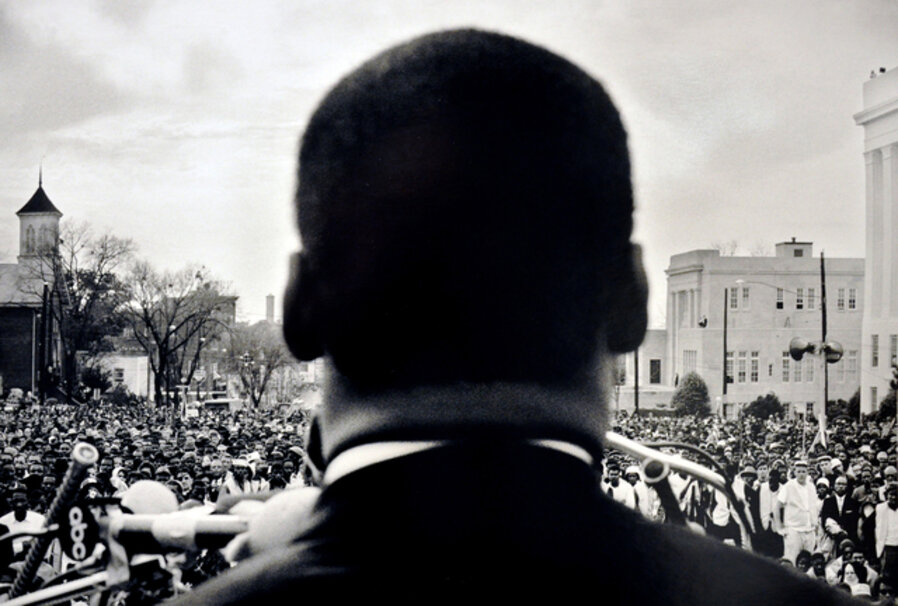 Dr. Martin Luther King, Jr., seen from his back, speaking before 25,000 civil rights marchers, in front of the Alabama state house - 1965 Selma to Montgomery, Alabama Civil Rights March - March 25, 1965