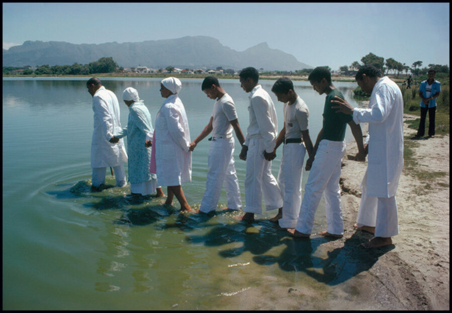 Members of the Redeemed Church of Christ head into the water for a full immersion baptism ceremony. Near Cape Town, South Africa