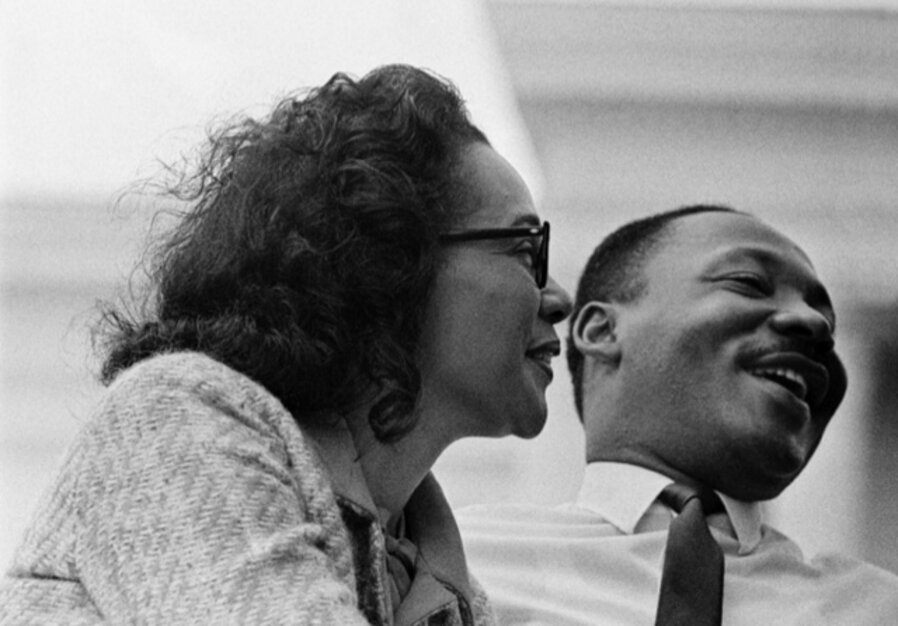 Dr. Martin Luther King, Jr., and wife Coretta Scott King, on speaker's platform for 1965 Selma to Montgomery Civil Rights March - Before Alabama State Capital building and 25,000 civil rights marchers - March 25, 1965