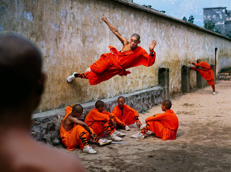 A young monk runs along the wall over his peers at the Shaolin Monastery in Henan Province, China
