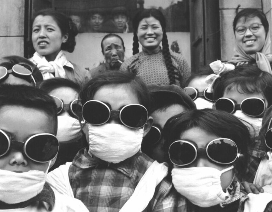 Schoolgirls wearing face masks and goggles (to protect them from sand from the Gobi Desert), China
