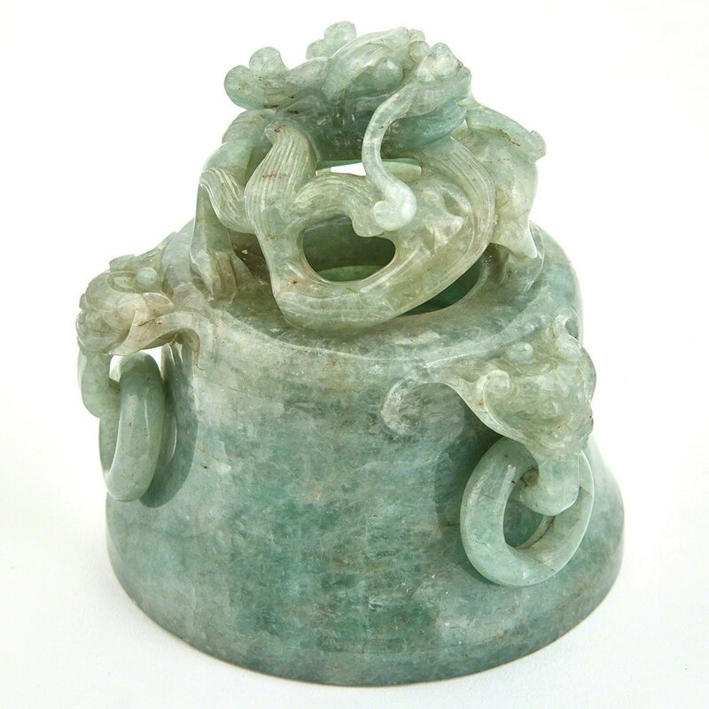 ‘Chinese Hardstone Covered Censer’, Design/Decorative Art, The compressed bombé body resting on three cabriole legs issuing from lion masks, the body flanked by a pair of dragon head handles suspending loose rings, the domed lid with three animal mask handles suspending loose rings and surmounted by a coiled dragon finial, the stone of a pale variegated celadon and apple green color., Doyle