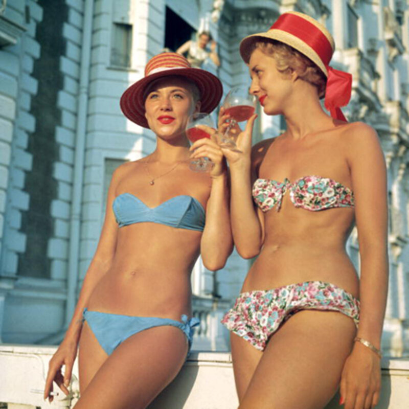Slim Aarons, ‘Sundowners, circa 1958: Two bikini-clad holidaymakers enjoy a glass of wine outside the Carlton Hotel, Cannes’, 1958, Photography, C-Print, Staley-Wise Gallery