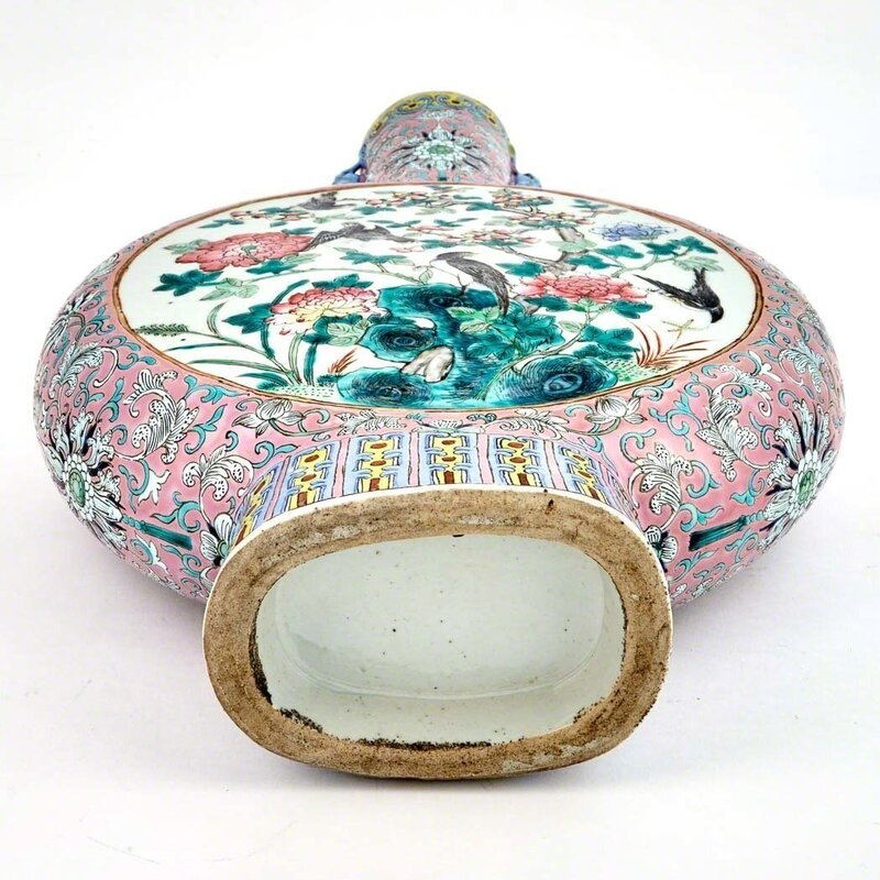 ‘Pair of Chinese Famille Rose Glazed Porcelain Moonflasks’, Design/Decorative Art, Each flattened globular body rising from a spread foot to a tall cylindrical neck, the neck flanked by a pair of chilong handles, each side decorated with a gilt rimed medallion enclosing a scene of two pheasants perched on stylized rockwork amongst chrysanthemum, magnolia, and peony blossoms, the reverse with further birds amongst rockwork and flowering plants and blooms, all reserved on a pink ground with scrolling lotus between lappet and ruyi bands., Doyle