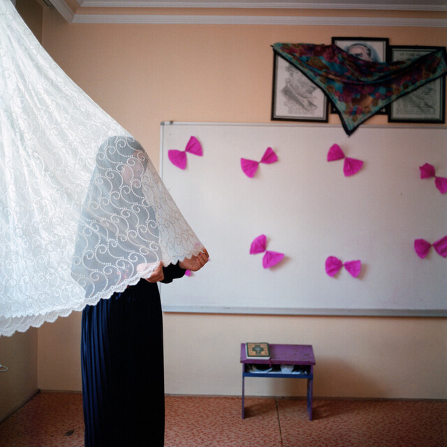 A shy student hides behind a curtain. A portrait of Atatürk, Turkey’s founding father, is covered by a scarf, because the presence of images of humans or animals in a room where you are praying or reading the Quran is discouraged in Islam. Istanbul