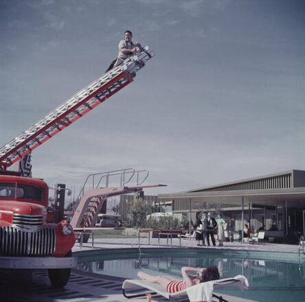 Slim Aarons, ‘To Any Lengths, 1954: Slim Aarons photographing Mara Lane from the top of an extending ladder by the swimming pool a Sands Hotel, Las Vegas’, 1954