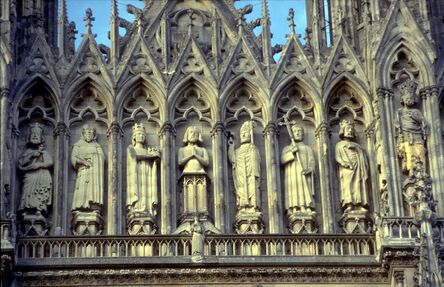 ‘Reims Cathedral: exterior, detail of West facade showing upper levels, niche statues of the French monarchy and Saints of France’, ca. 1211-1290