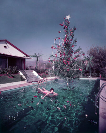 Slim Aarons, ‘Christmas Swim, 1954: Rita Aarons swimming in a pool festooned with floating baubles and a decorated Christmas tree, Hollywood, California’, 1954