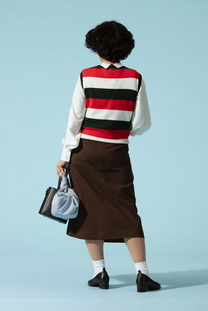 Woman In A Striped Sweater Vest And A Sepia Velvet Skirt