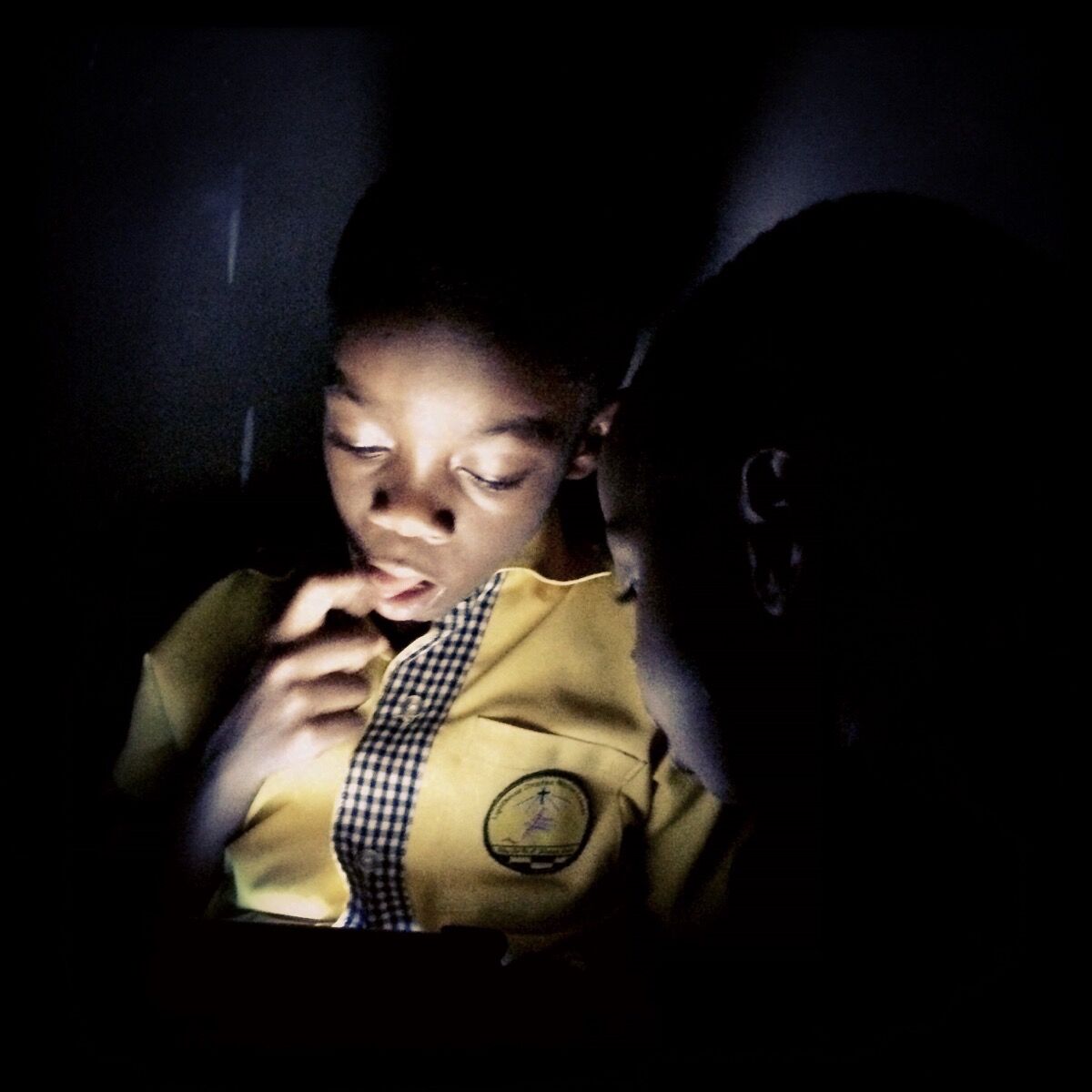 Paakow tries to answer a difficult question on the iPad while his younger brother Ato looks on. Accra, Ghana. Photo by @africashowboy.