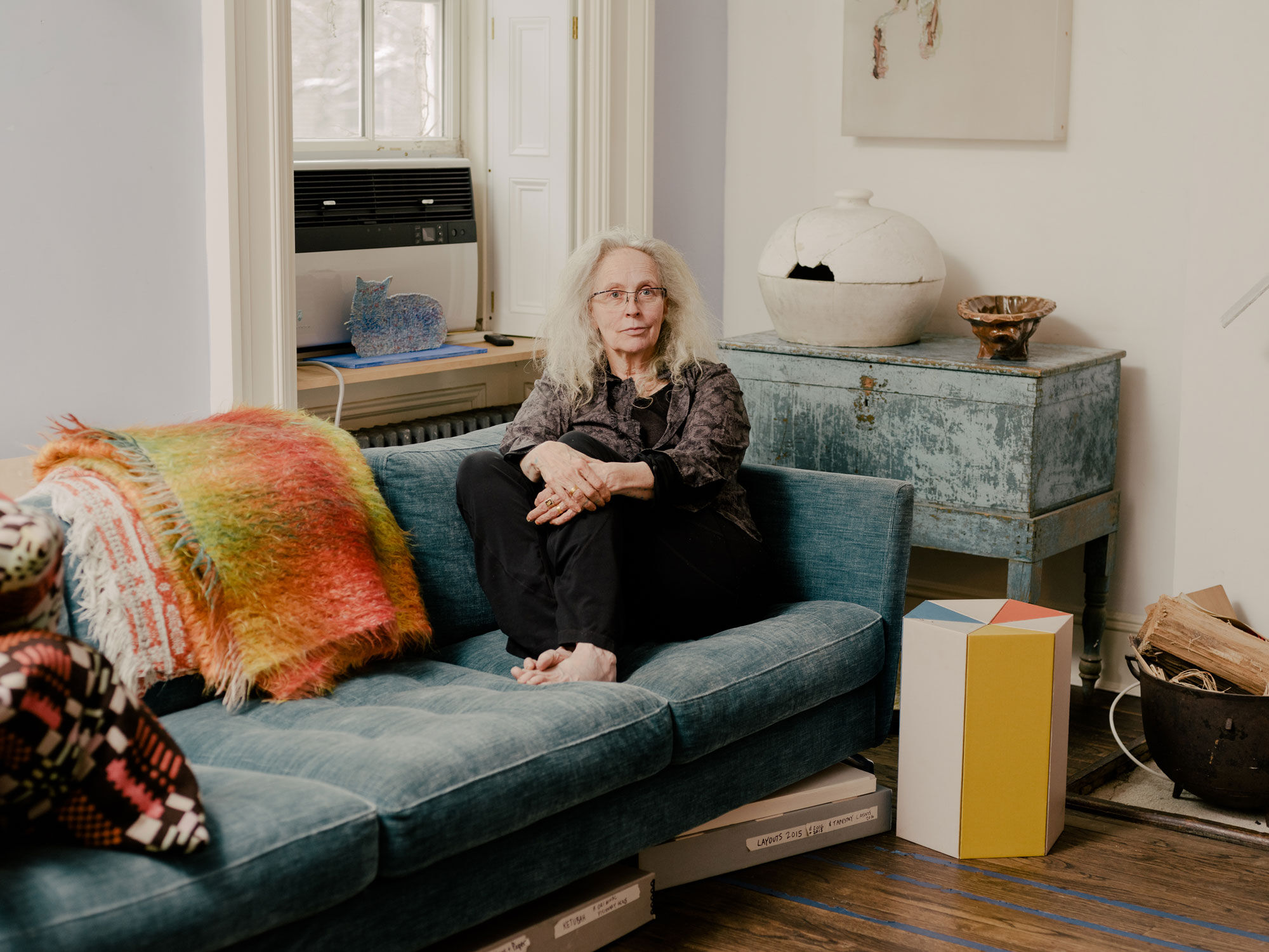 Portrait of Kiki Smith in her New York home and studio. Below the couch, archival boxes store rubbings and templates from past work. Portrait by Daniel Dorsa for Artsy. 