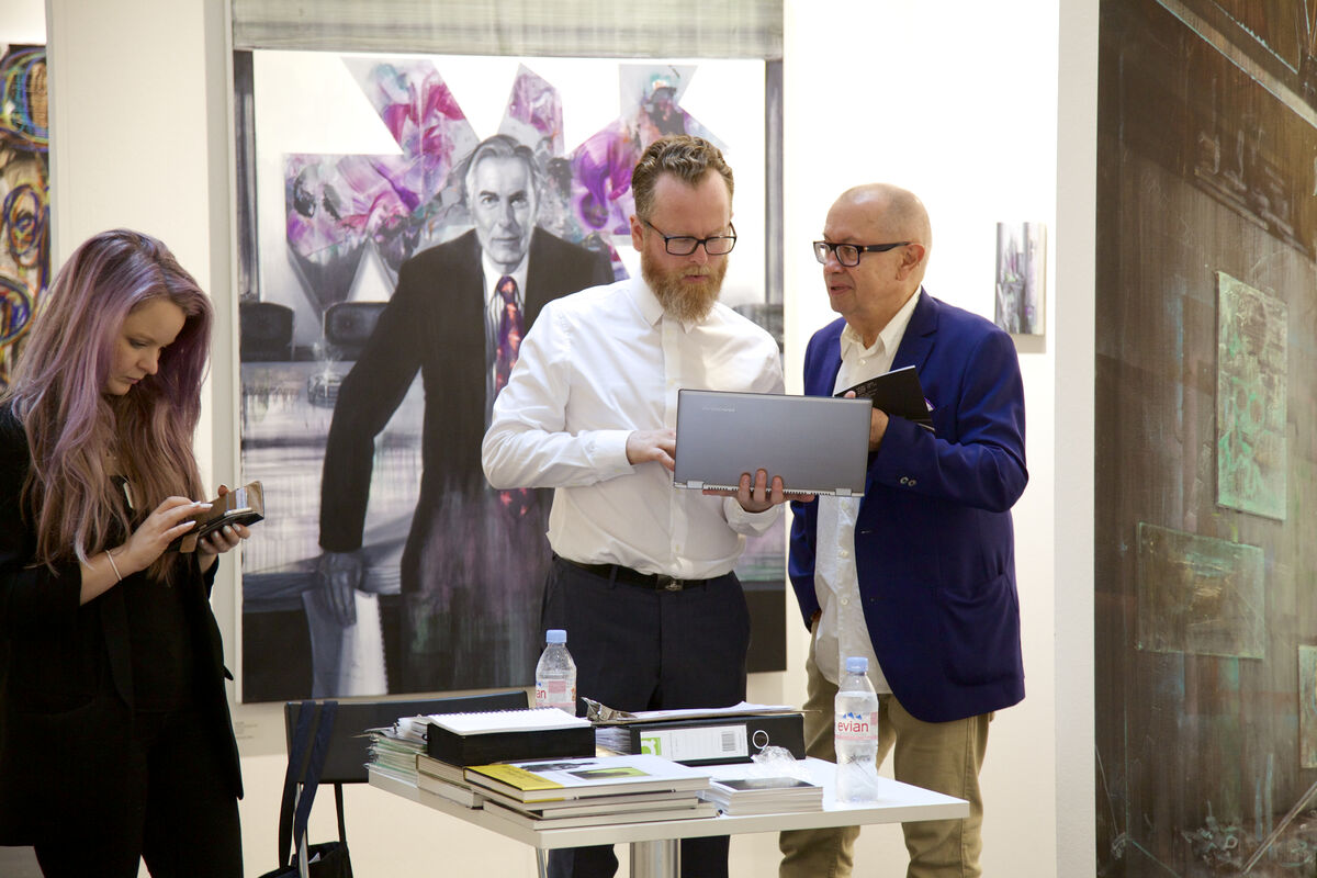 Zavier Ellis (center, owner of Charlie Smith London) confers with a collector as gallery manager Rosanna Dean follows up with correspondence. A new Tom Butler painting, part of the gallery’s ‘Interiority’ curated booth, looks on; Courtesy VOLTA13