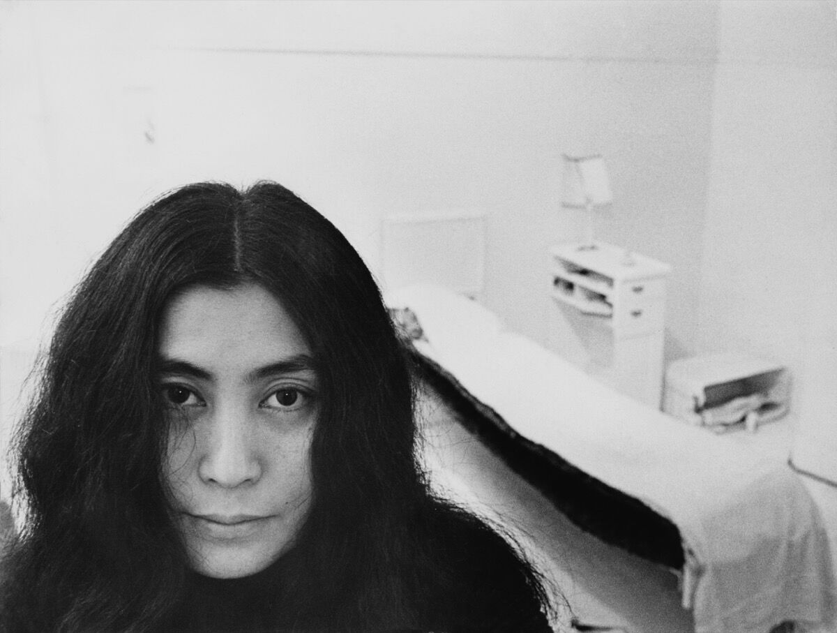 Japanese artist and musician Yoko Ono sits in a white-painted half bedroom entitled Half-a-Room, in “Half-a-Memory” exhibition, at the Lisson Gallery, London, 1968. Photo by Roger Jones/Keystone Features/Getty Images.