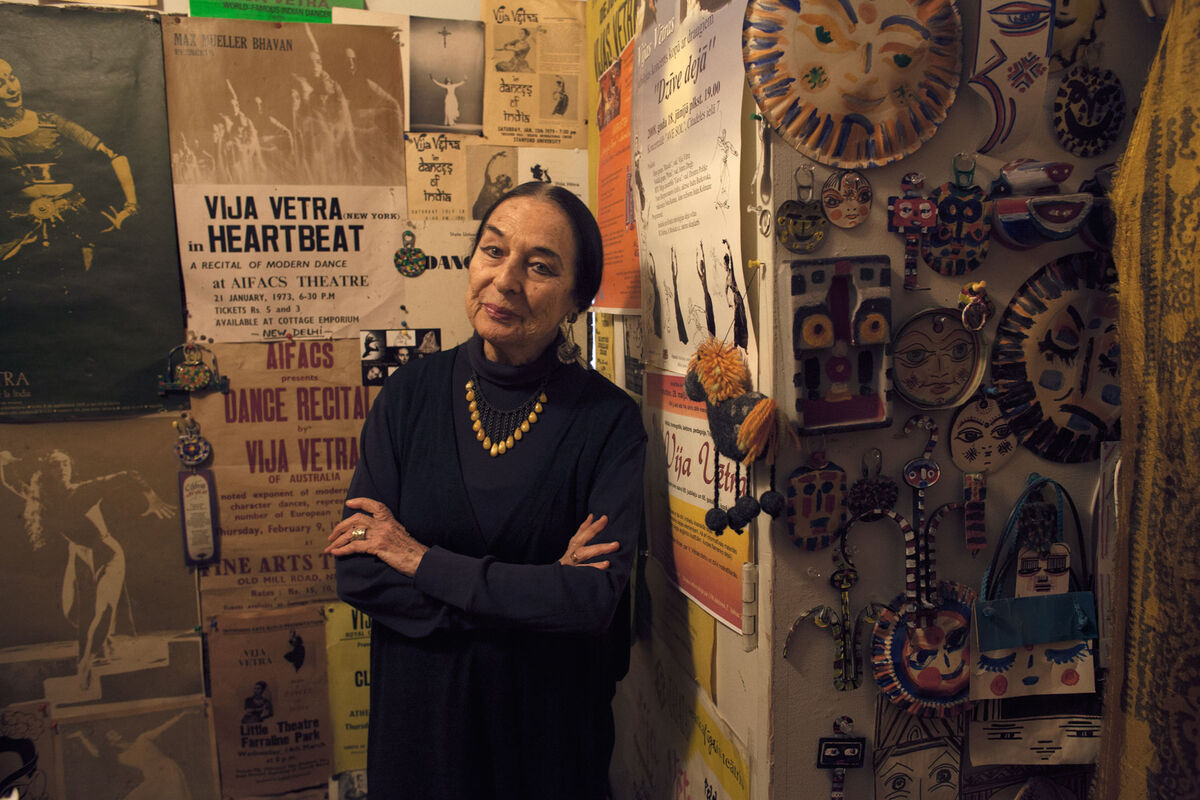 Latvian dancer and choreographer Vija Vetra, who will turn 96 on February 6th, stands in her front entry hall, surrounded by her artwork and posters from past performances. Vetra continues to conduct yoga and dance classes from her Westbeth studio. Photo by Frankie Alduino.