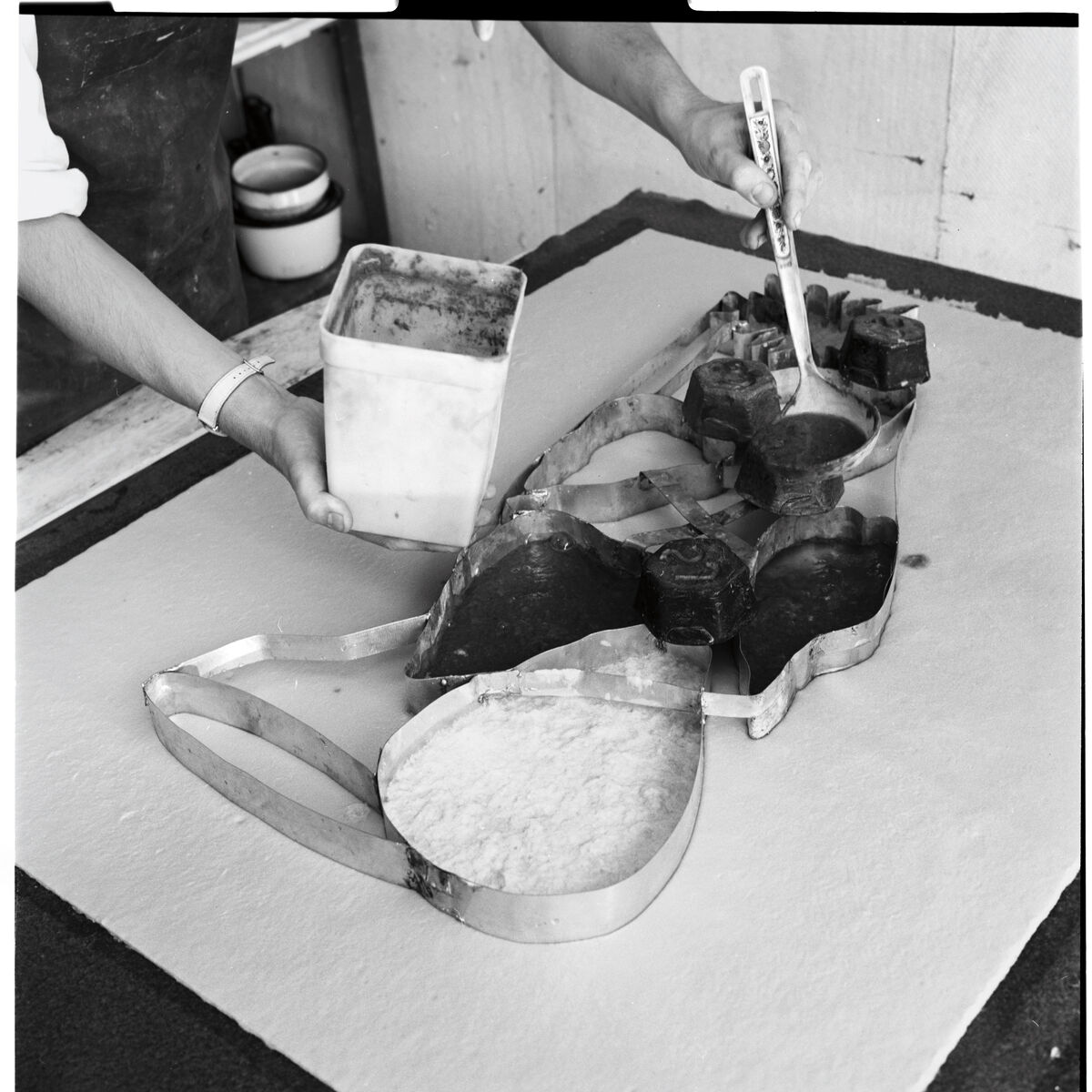 David Hockney spoons colour pulp into a cookie-cutter mould for Sunflower 1, from the Paper Pools series, Tyler Workshop Ltd. paper mill, Bedford Village, New York, 1978. Photographer: Larry Stanton. National Gallery of Australia, Canberra. Gift of Kenneth Tyler, 2002.&nbsp;
