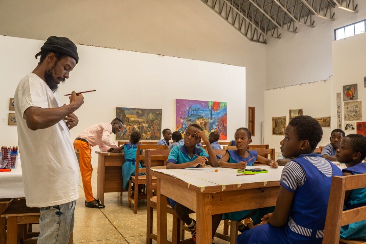 Savannah Centre for Contemporary Art (SCCA) Tamale Artistic Director guiding students through a series of workshops as part of Ghanaian artist Galle Winston Kofi Dawson’s retrospective, “In Pursuit of something ‘Beautiful’, perhaps…,” 2019–2020. Courtesy of SCCA Tamale.