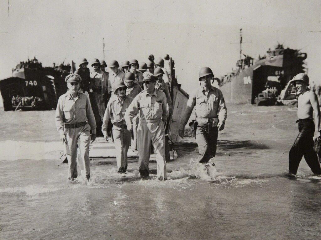 Gen. Douglas MacArthur with Gen. Richard Sutherland and Col. Lloyd Lehrbas walks through the surf to the beach at Lingayen, Luzon, the Philippines